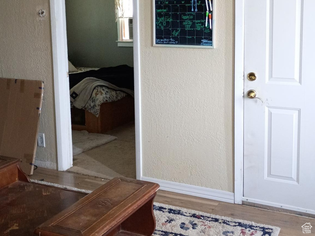 Entryway with wood finished floors and a textured wall