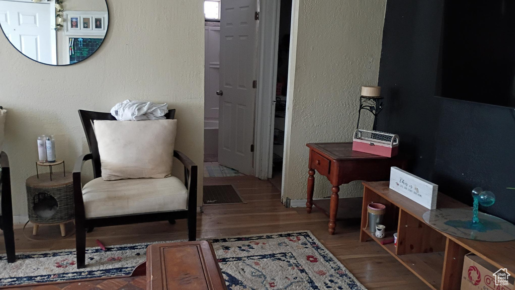 Living area featuring a textured wall and wood finished floors