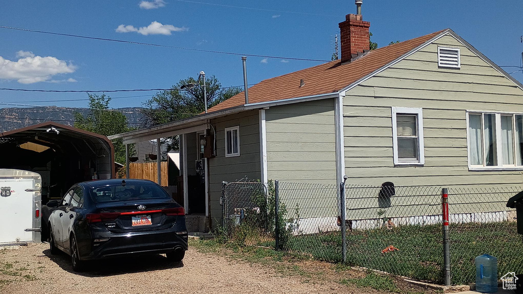 View of side of property featuring a carport and a chimney