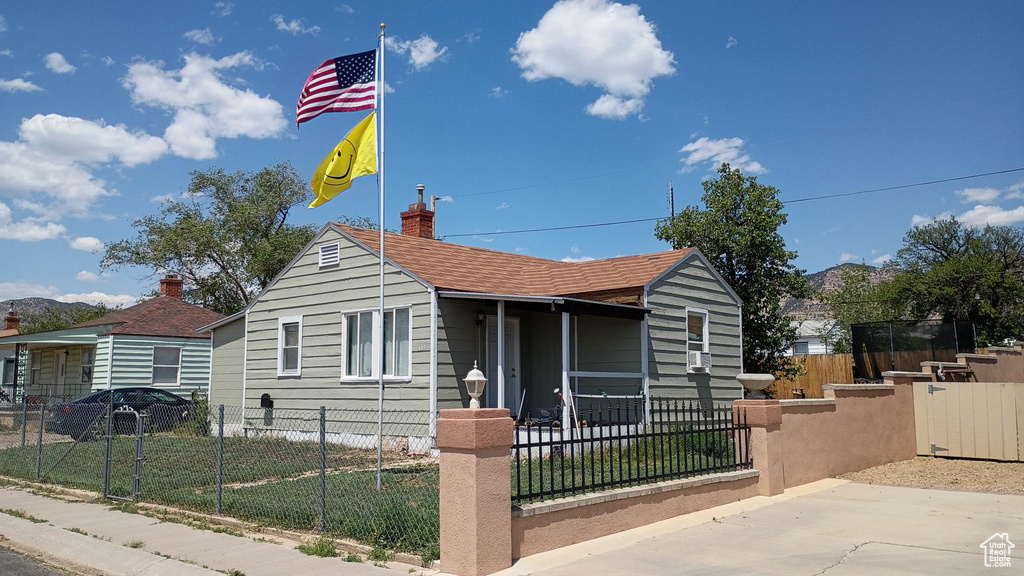Bungalow featuring a fenced front yard and a chimney