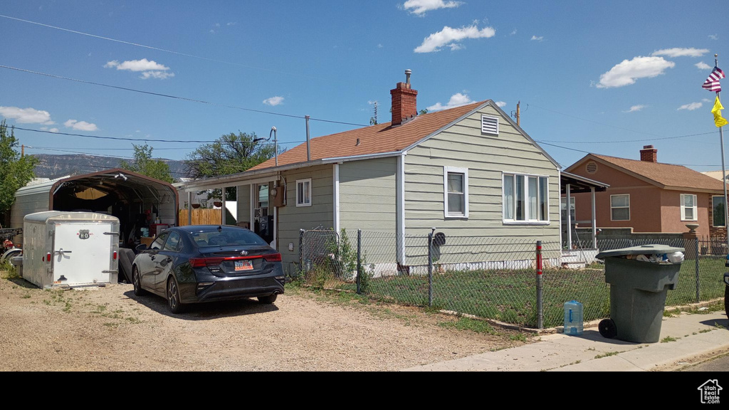 View of home\\\\\\\\\\\\\\\\\\\\\\\\\\\\\\\'s exterior with a carport, a chimney, and dirt driveway
