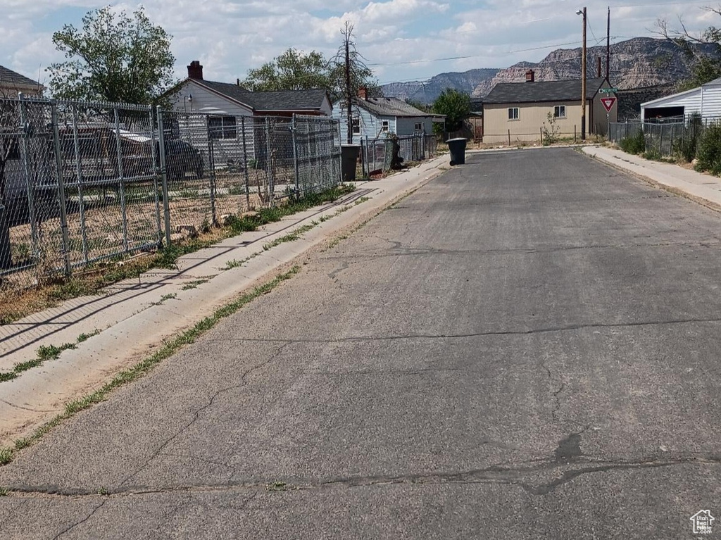 View of asphalt street featuring sidewalks and curbs