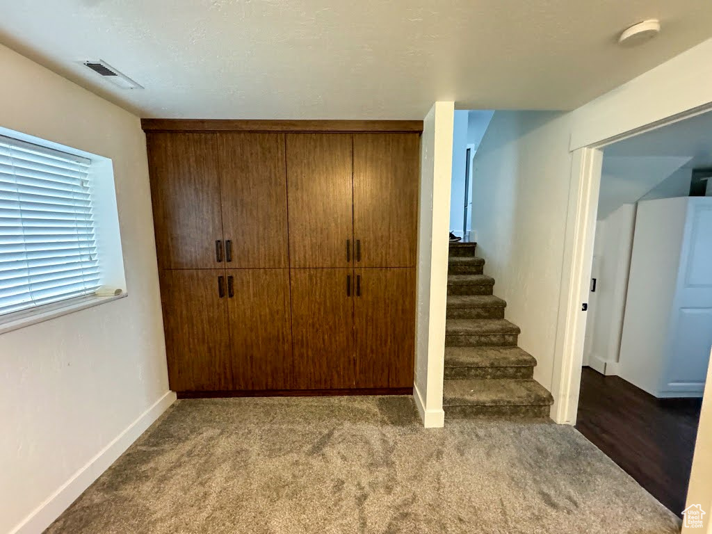 Below grade area featuring stairway and carpet floors