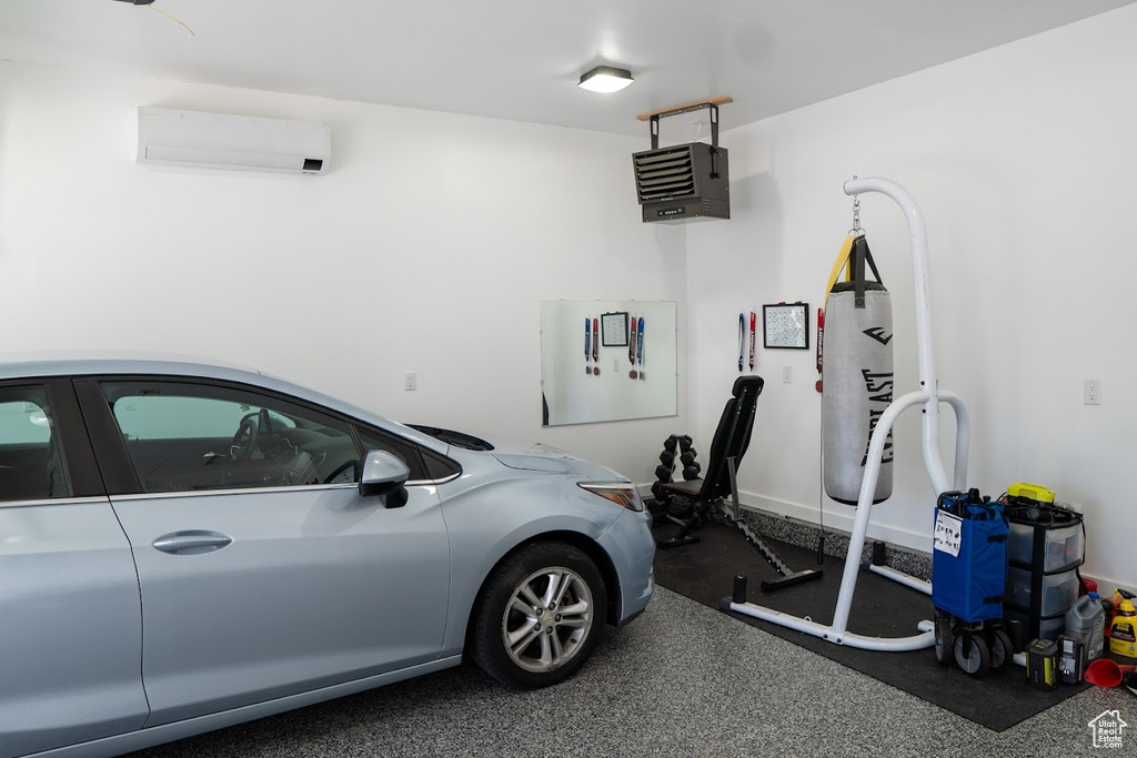 Garage featuring a wall mounted AC and a heating unit