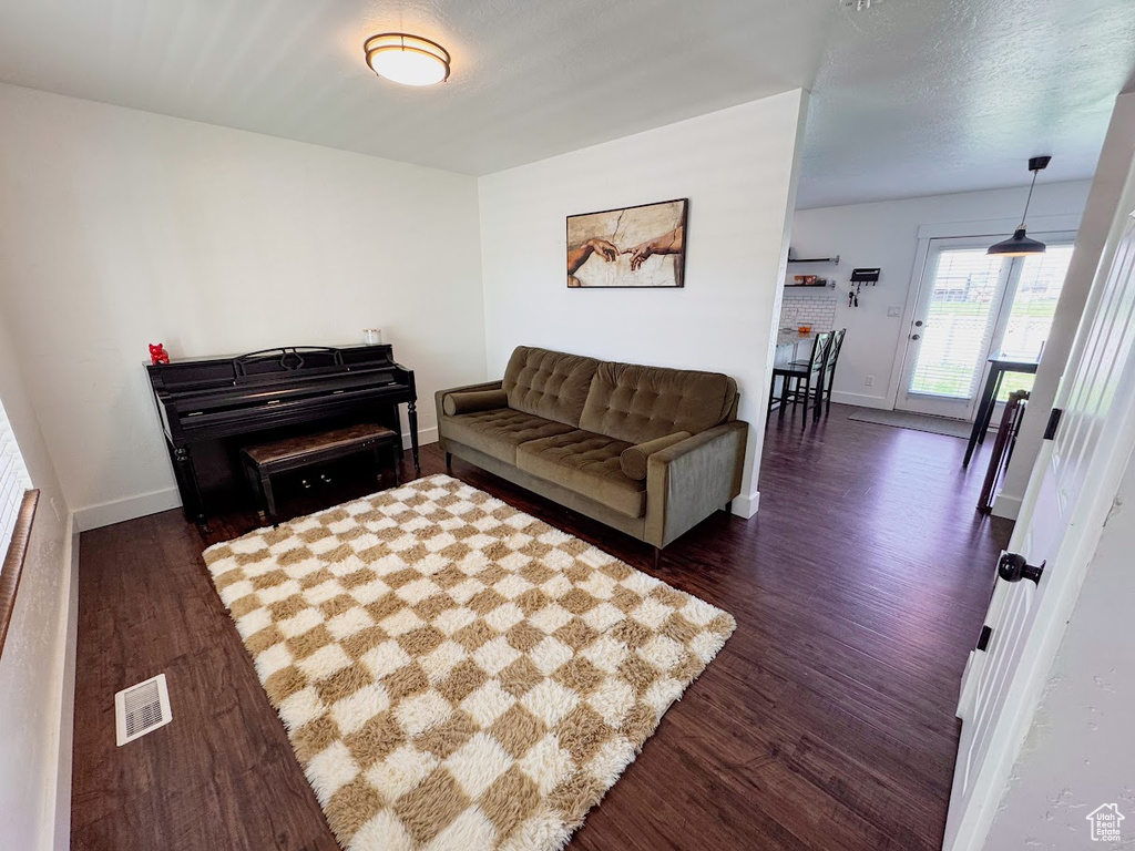 Living room with dark wood-style floors and baseboards