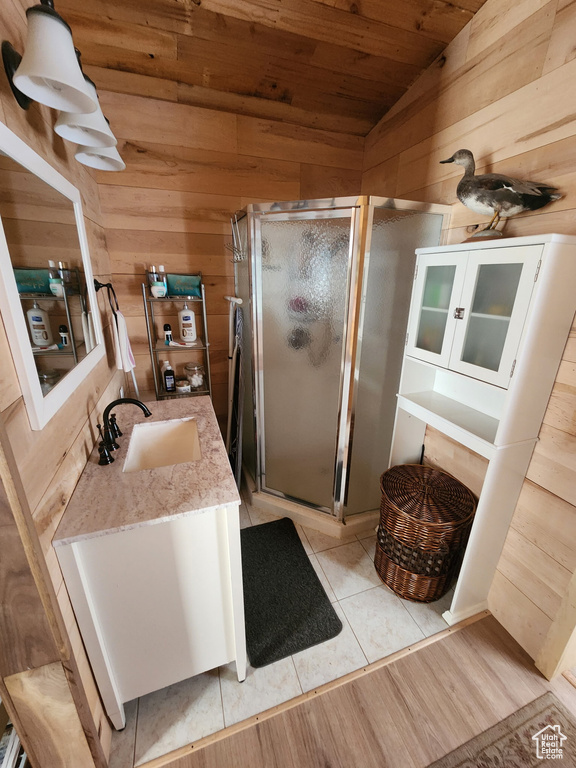 Bathroom featuring wooden ceiling, vaulted ceiling, wooden walls, vanity, and a stall shower