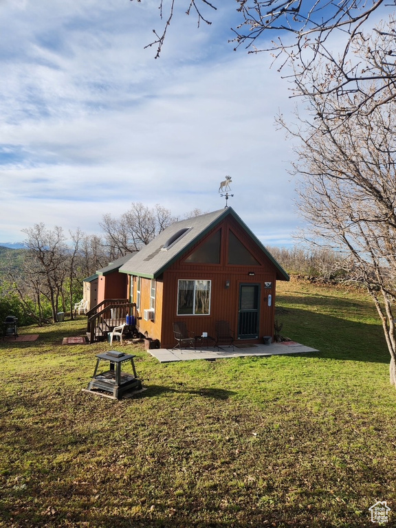 Back of property featuring a lawn and a patio