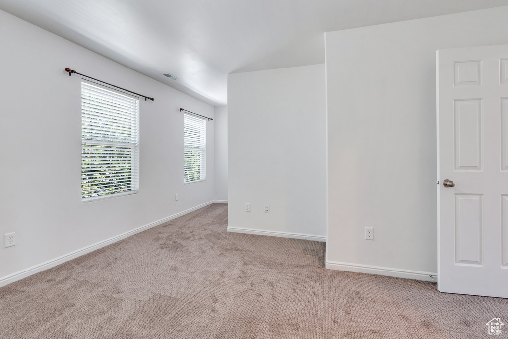 Spare room featuring carpet and baseboards