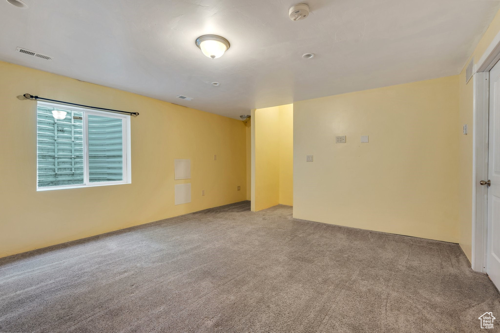Unfurnished room with a smoke detector and carpet floors