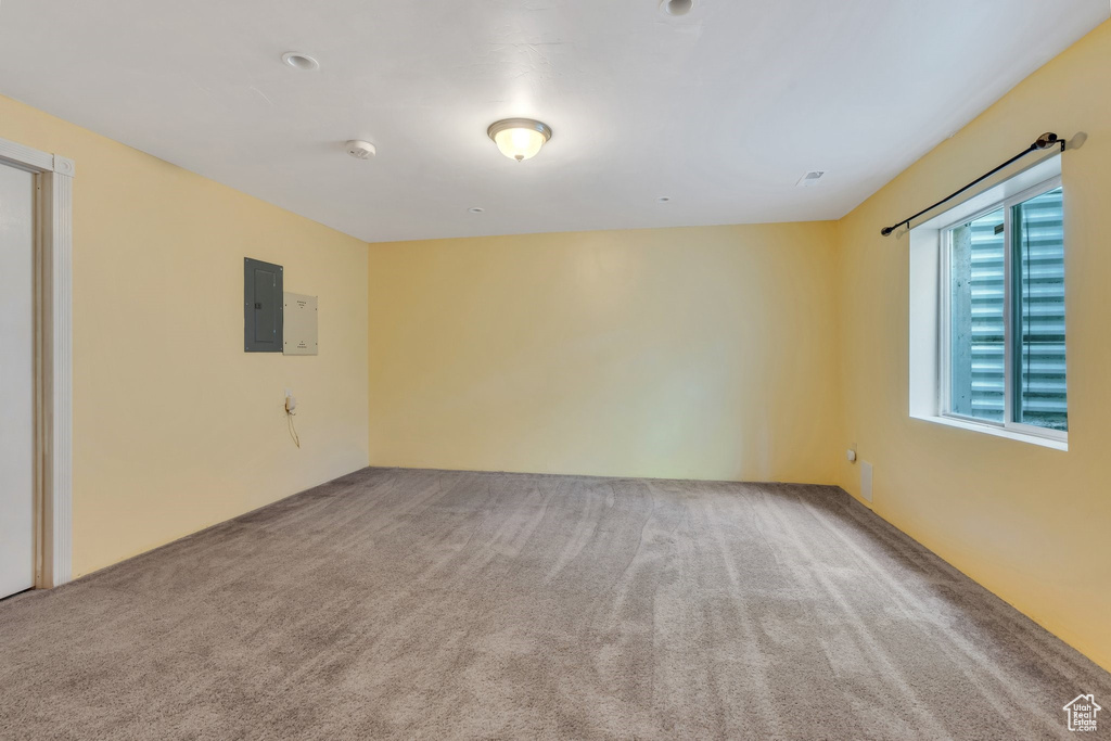 Unfurnished room with carpet flooring, electric panel, and a smoke detector