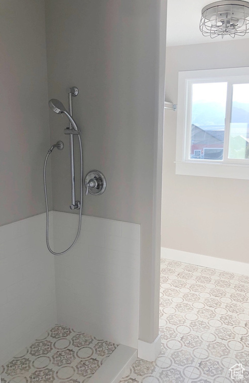Full bath with a stall shower and baseboards