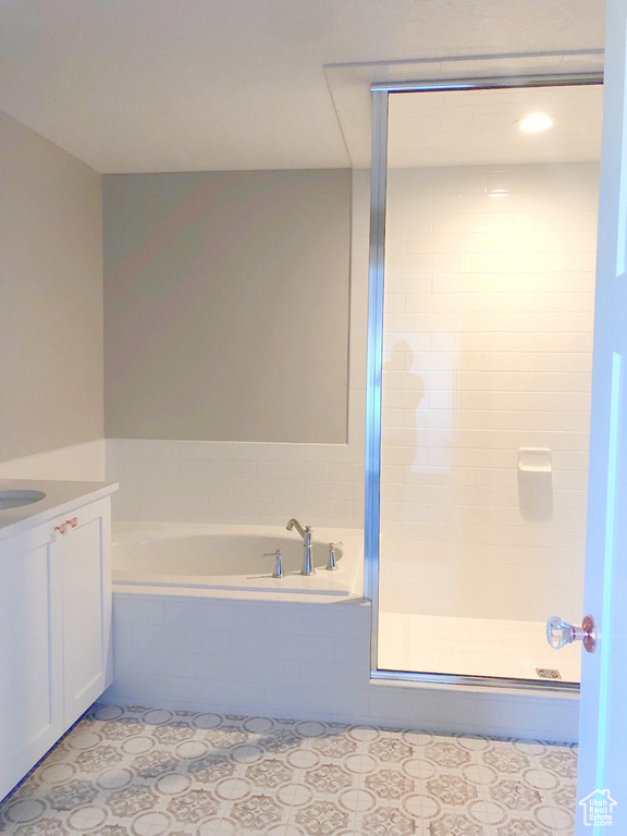 Bathroom with a garden tub, vanity, tile patterned flooring, and a stall shower