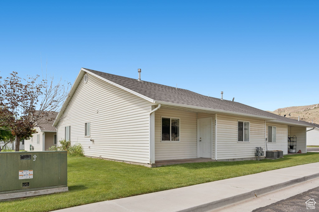 View of property exterior featuring a yard and roof with shingles