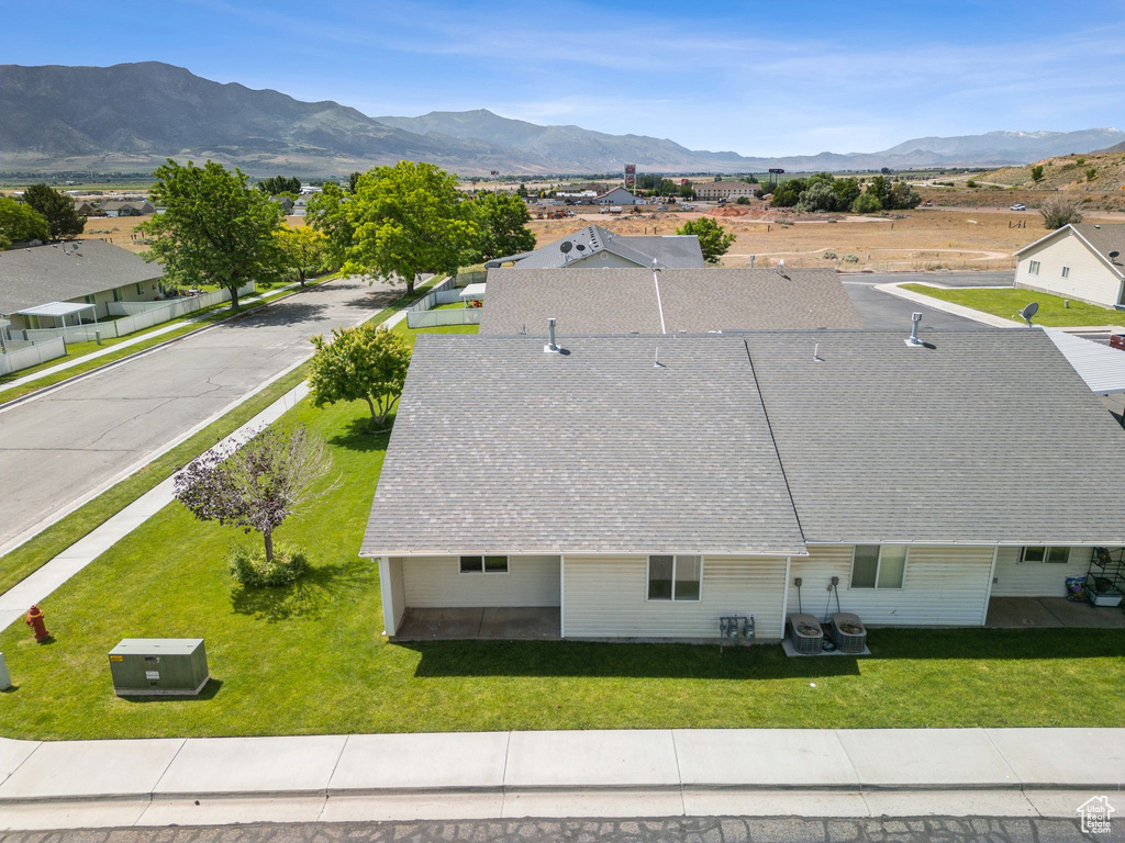 Aerial view of property and surrounding area with a mountain backdrop