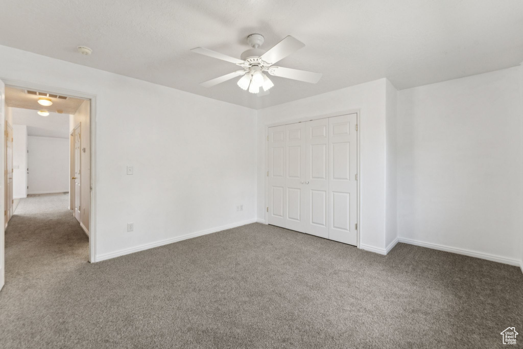 Unfurnished bedroom featuring carpet flooring, a closet, and ceiling fan