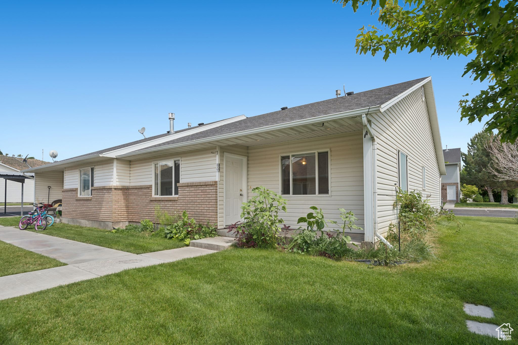 Ranch-style home with a front yard and brick siding