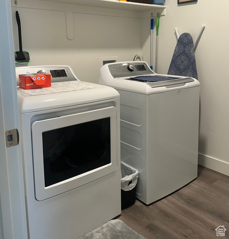 Washroom with washing machine and dryer and wood finished floors