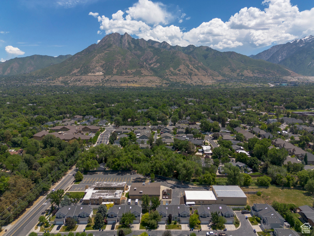Aerial view of property and surrounding area with nearby suburban area and mountains