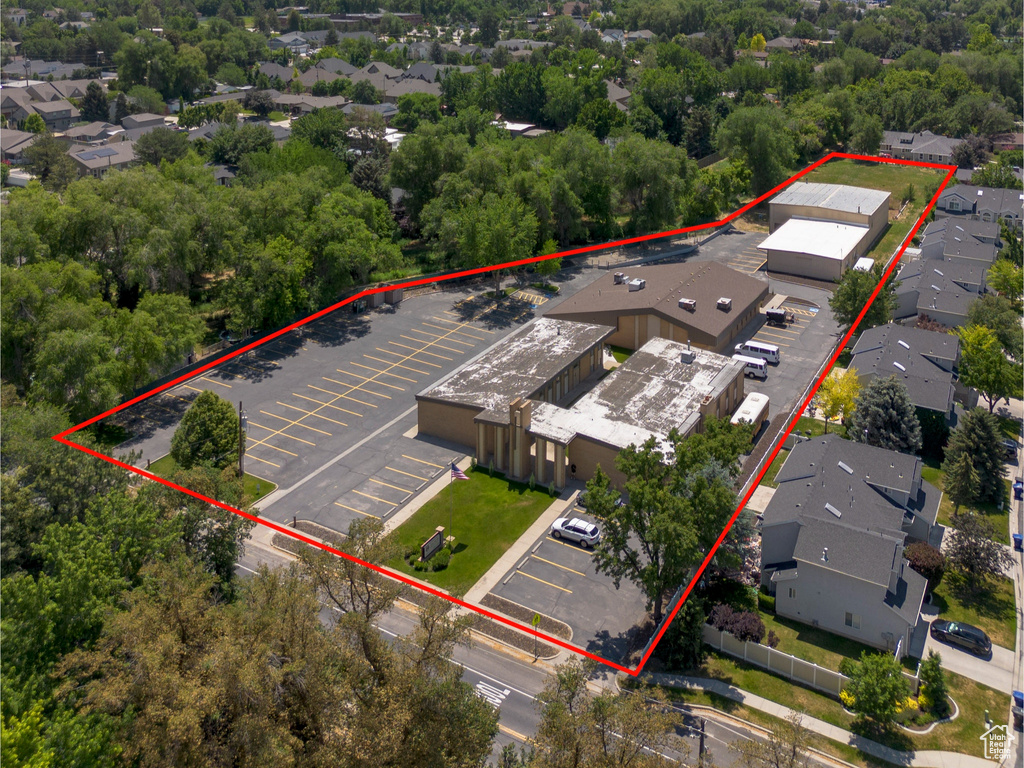 Aerial view of property and surrounding area with a mountainous background and property boundaries highlighted