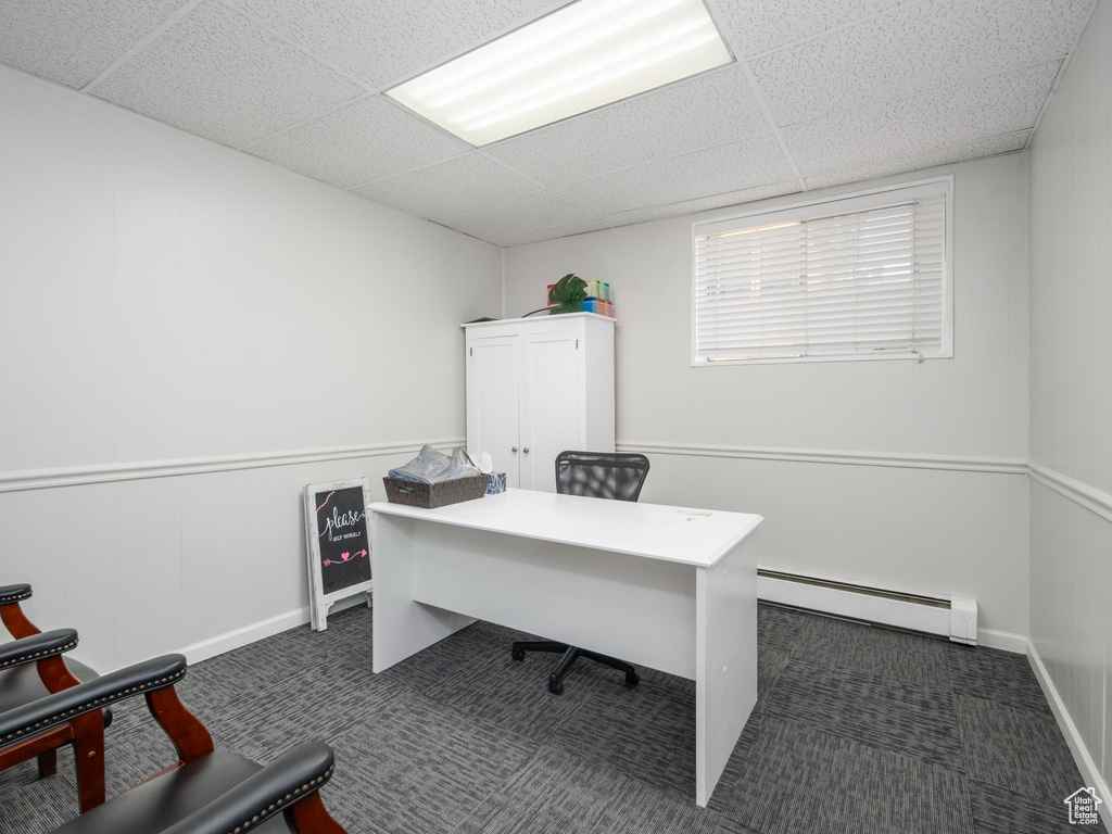Office space featuring a baseboard heating unit, a drop ceiling, and carpet floors