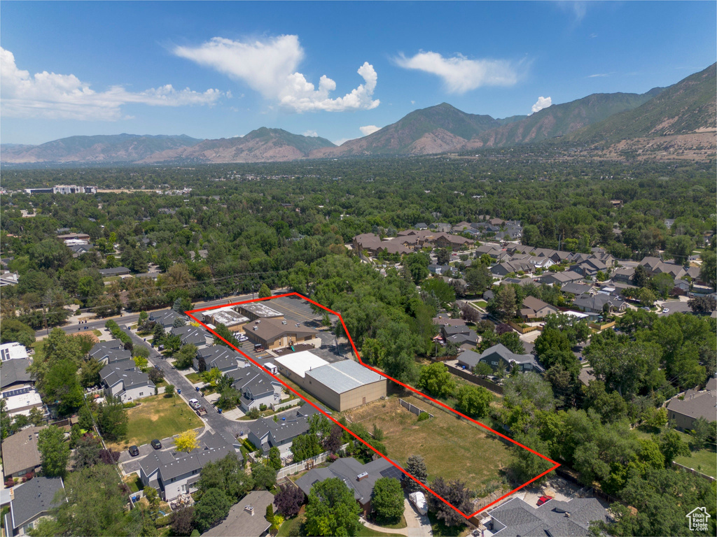 Aerial view of residential area featuring a mountainous background and property parcel outlined