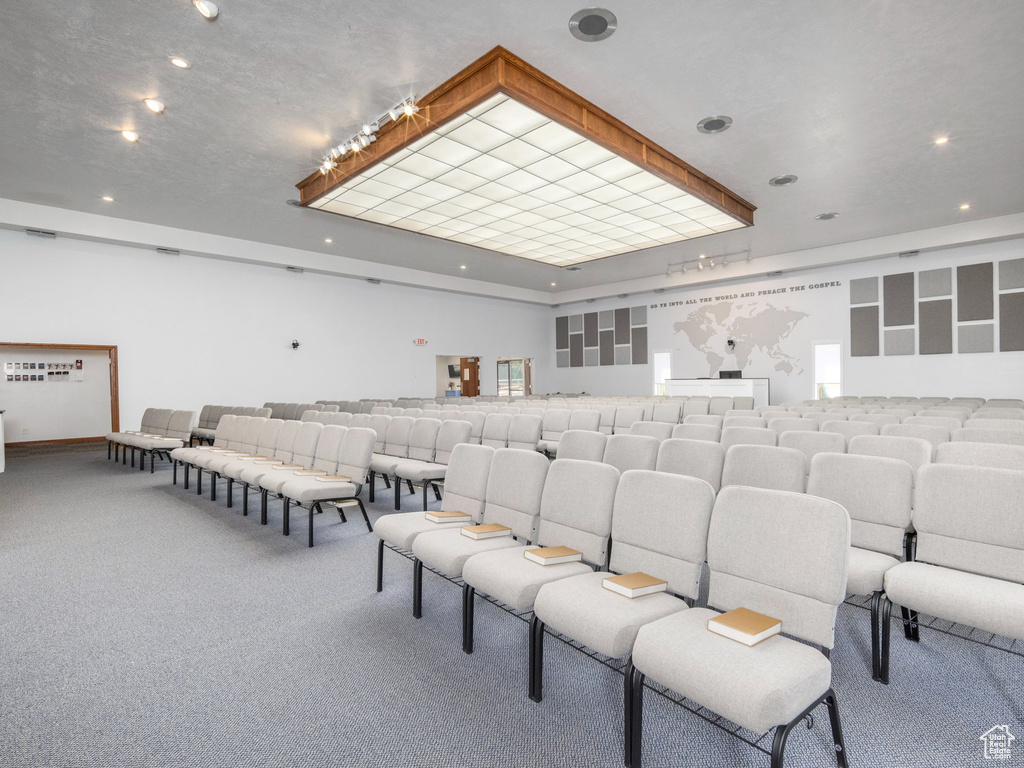 Carpeted home theater with a tray ceiling and recessed lighting