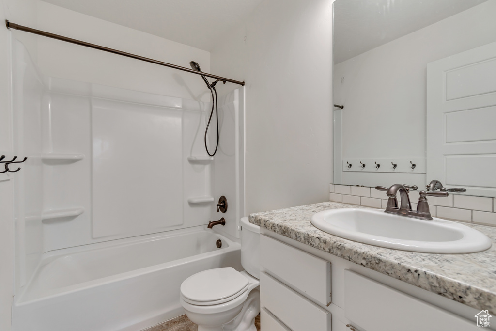 Full bathroom featuring vanity, washtub / shower combination, and backsplash