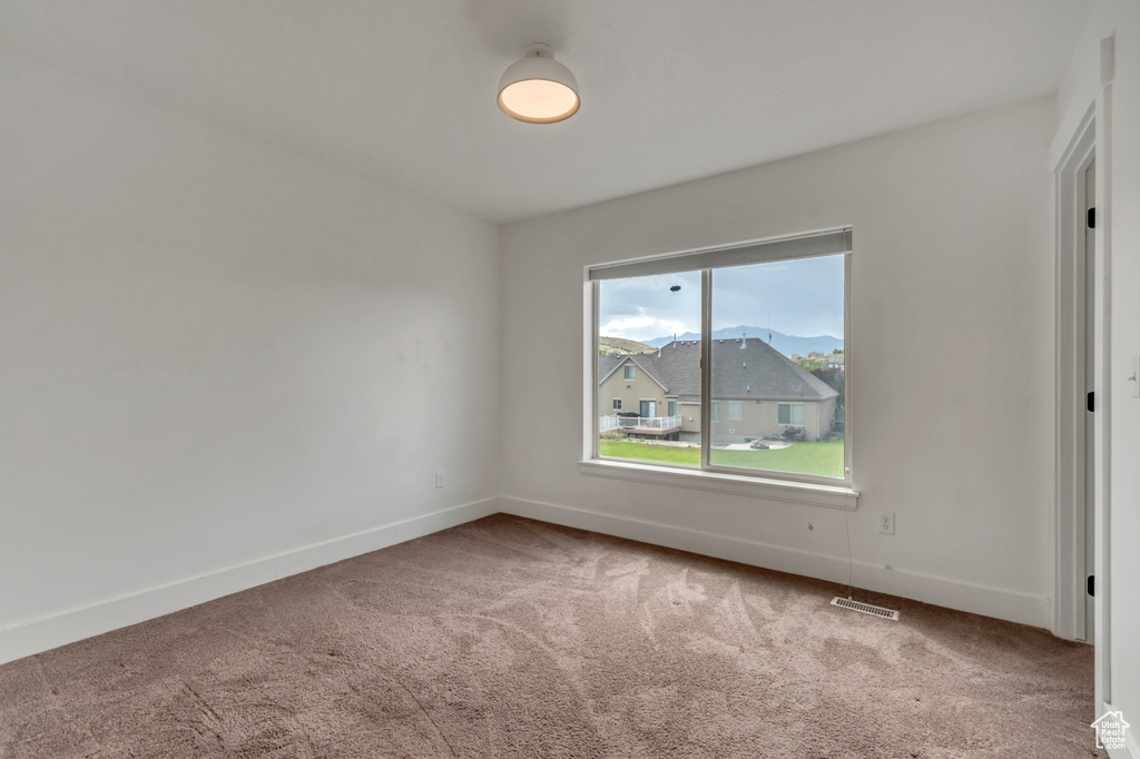 Carpeted spare room with baseboards