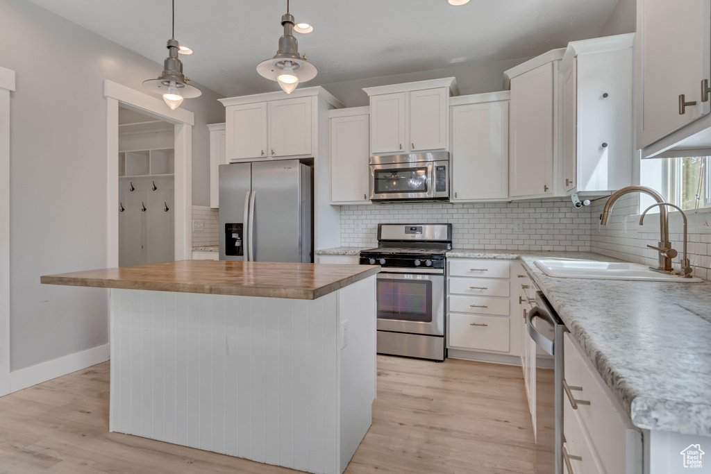 Kitchen featuring stainless steel appliances, light wood-style flooring, backsplash, and recessed lighting