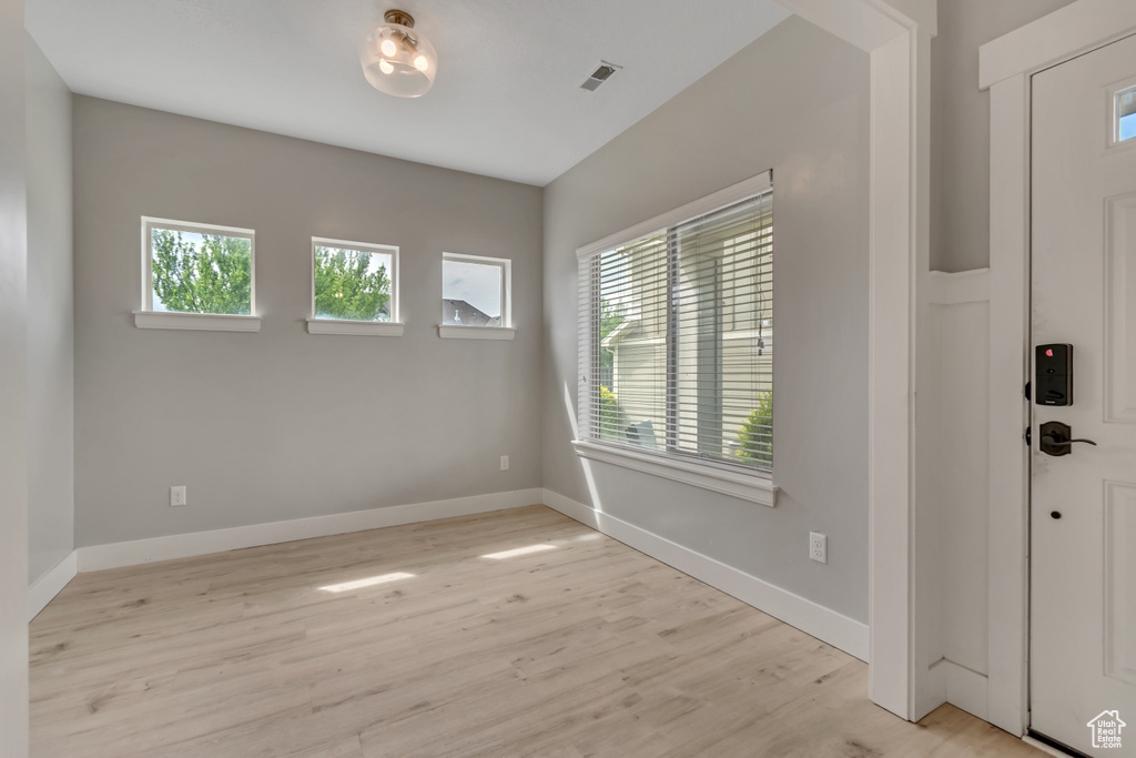 Foyer entrance featuring light wood-style floors and baseboards