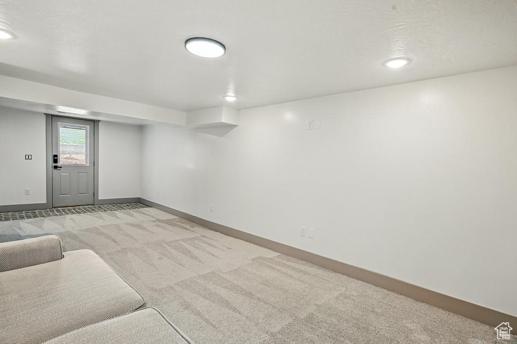 Below grade area with light carpet and baseboards