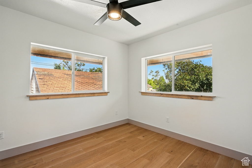 Spare room featuring plenty of natural light, light wood finished floors, and ceiling fan