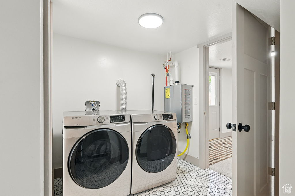 Washroom with washer and clothes dryer and tankless water heater