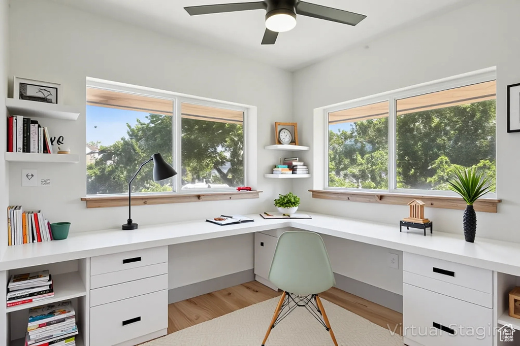 Office featuring built in desk, plenty of natural light, and light wood-style floors
