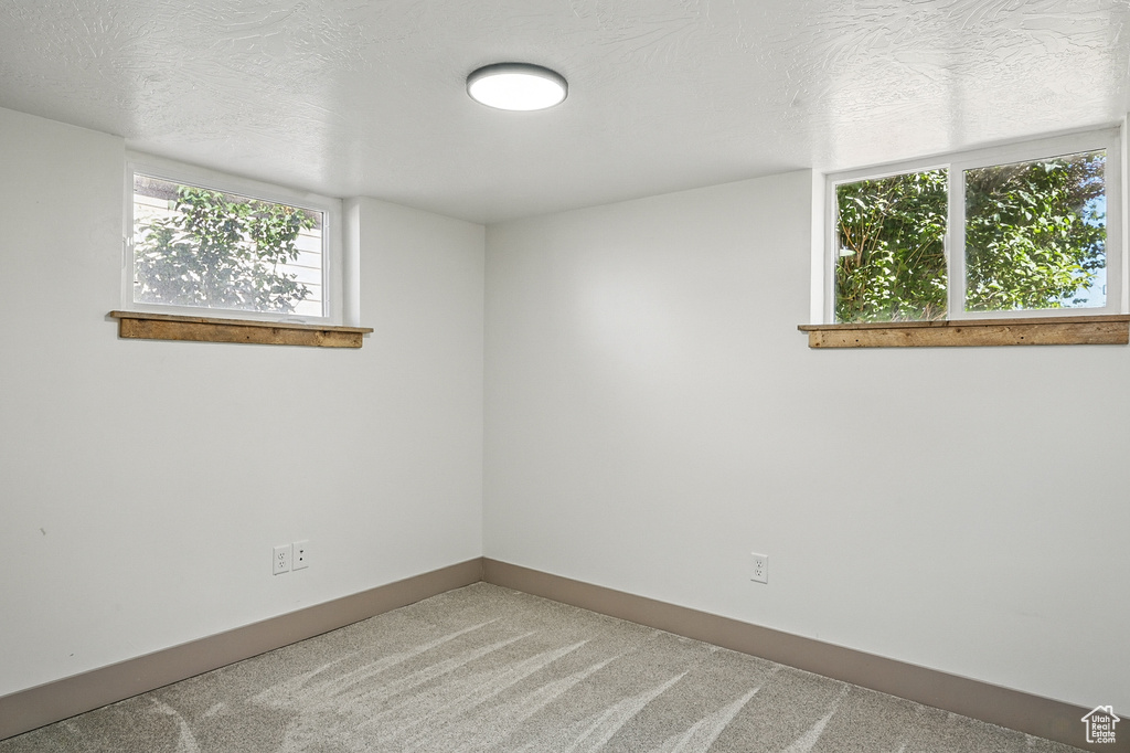 Carpeted spare room with a textured ceiling