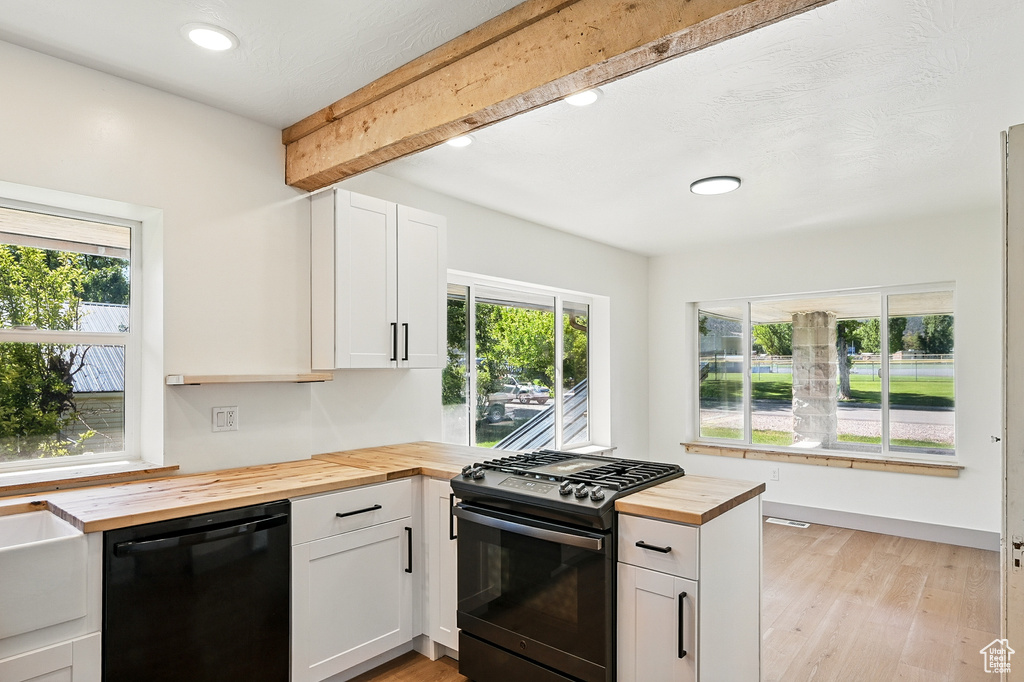 Kitchen featuring wood counters, black appliances, recessed lighting, beamed ceiling, and light wood-style floors
