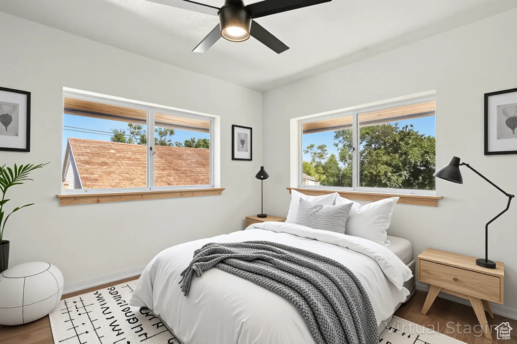 Bedroom with multiple windows, wood finished floors, and ceiling fan