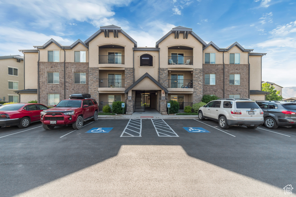 View of building exterior with uncovered parking