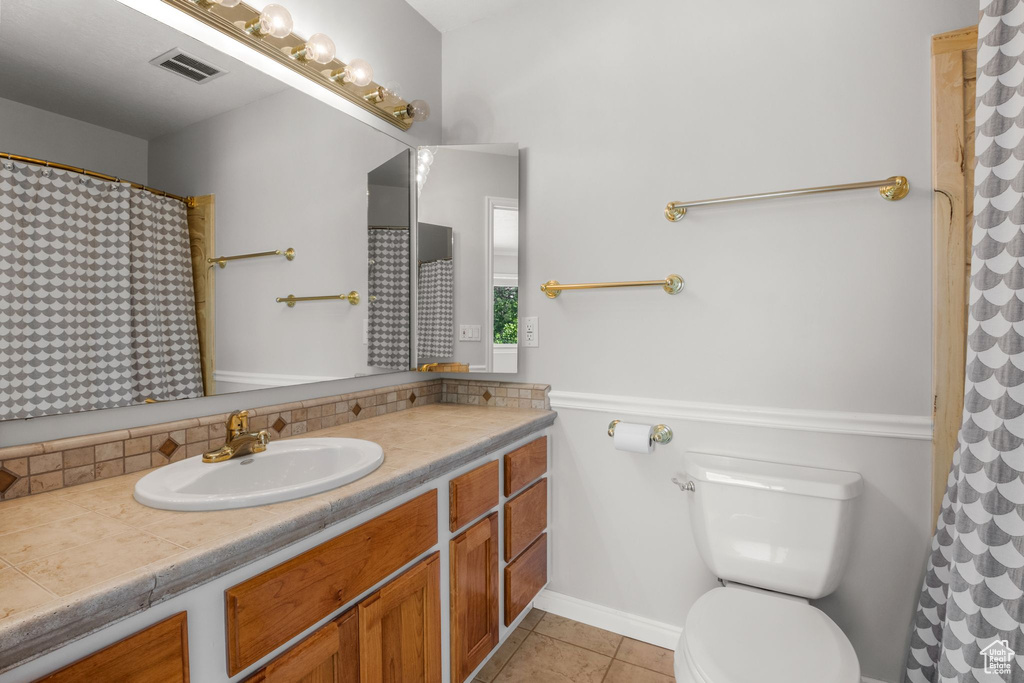 Bathroom with vanity, tile patterned flooring, and tasteful backsplash