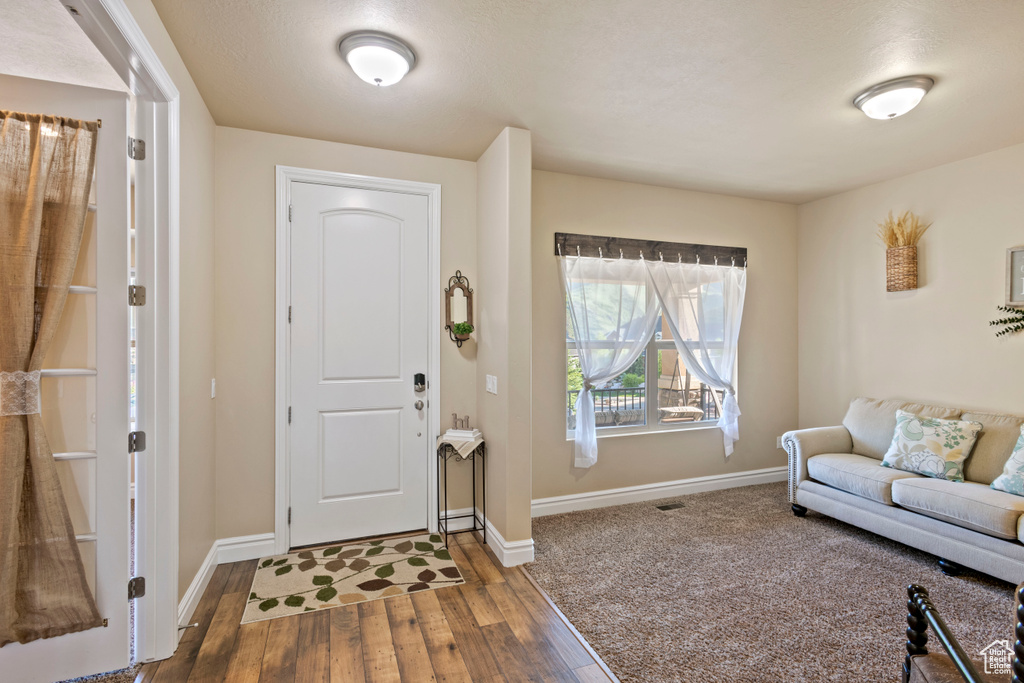 Foyer entrance with wood-type flooring and baseboards