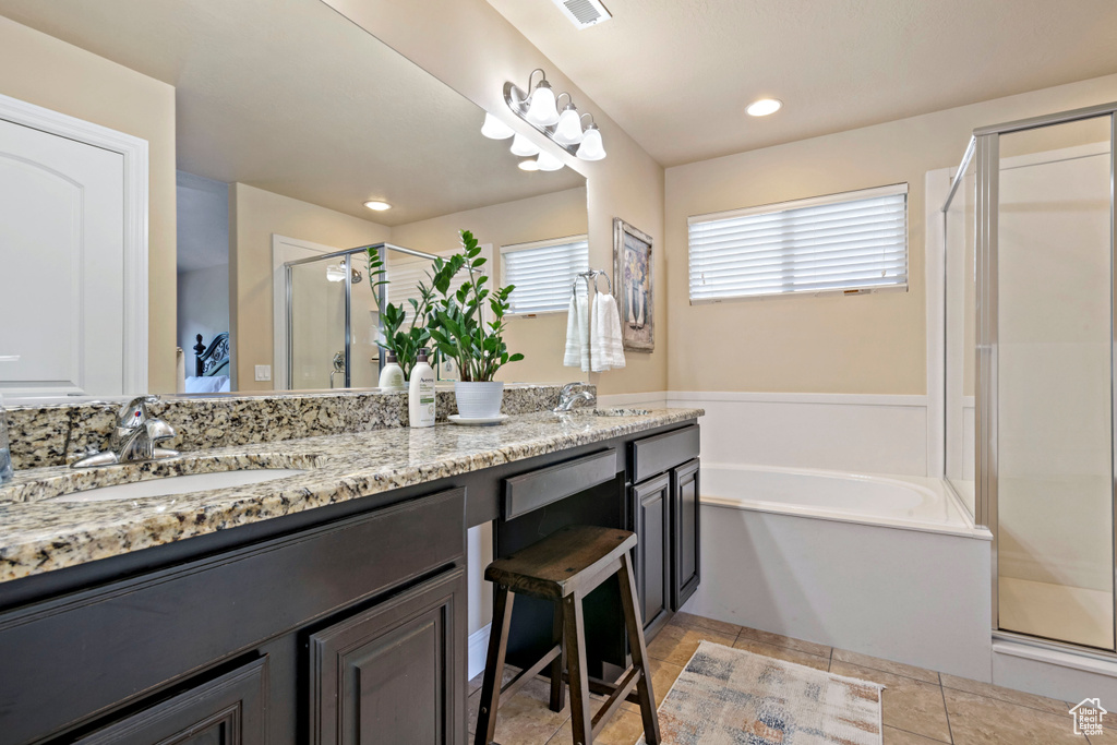 Full bathroom featuring a stall shower, double vanity, a bath, and recessed lighting