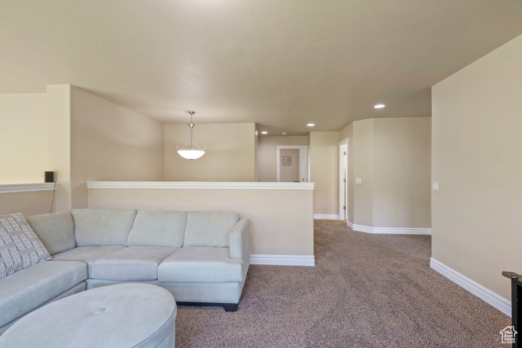 Carpeted living area featuring recessed lighting and baseboards