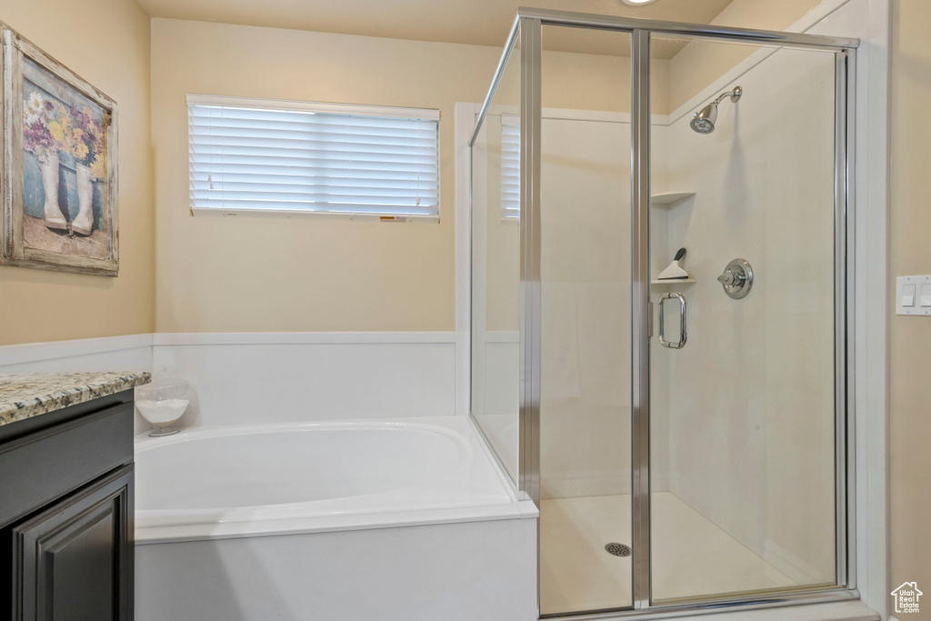 Bathroom with a bath, a stall shower, and vanity