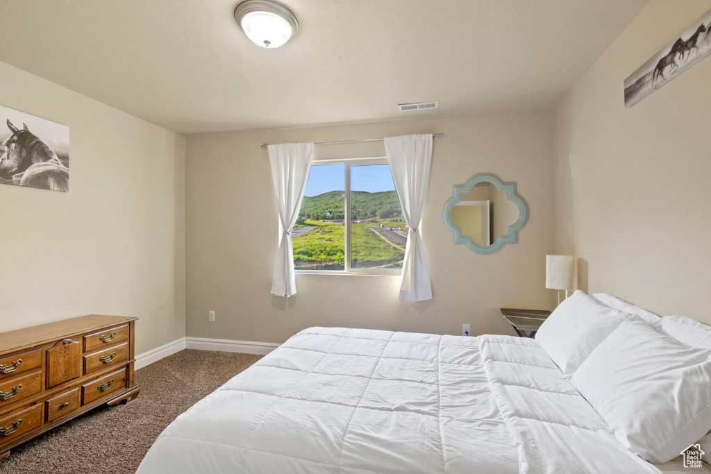 Carpeted bedroom with baseboards and a mountain view