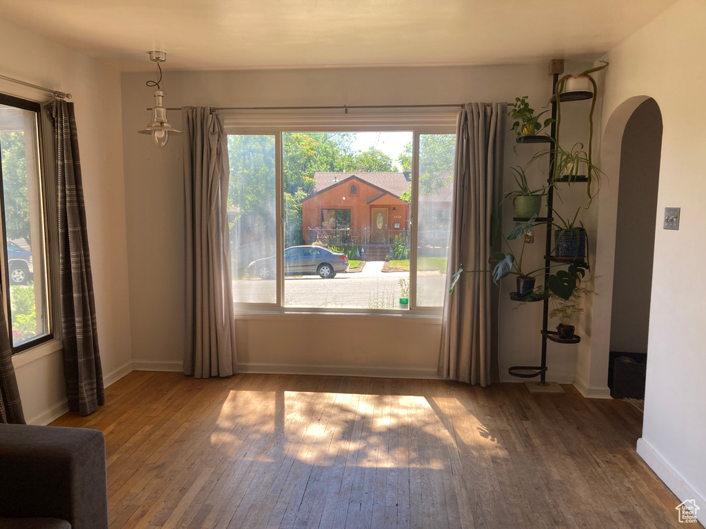 Spare room featuring arched walkways and hardwood / wood-style floors