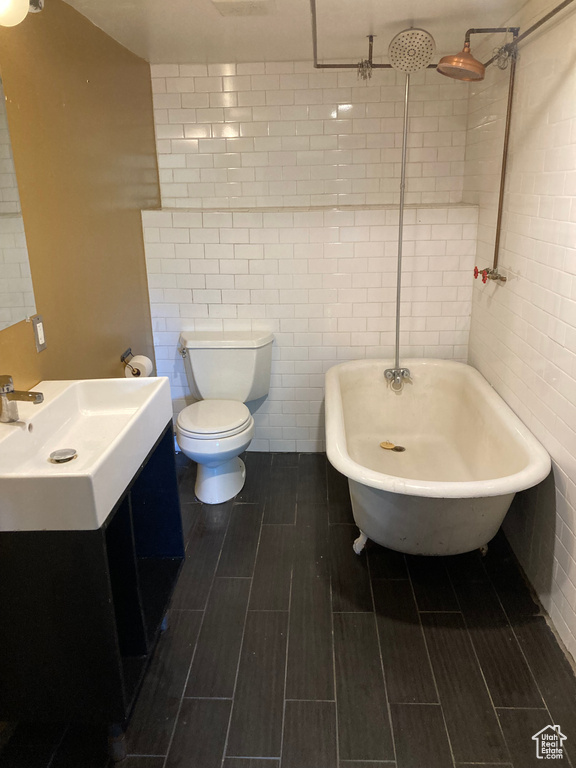 Full bathroom with vanity, tile walls, and a combined bath / shower with freestanding tub