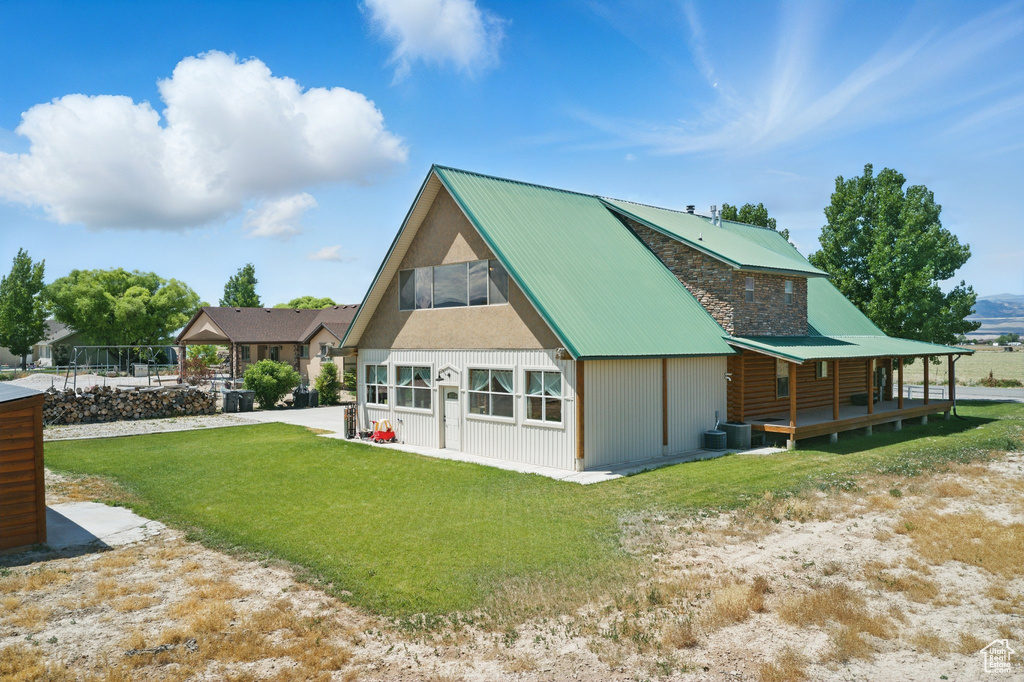 Rear view of house with a lawn and a metal roof
