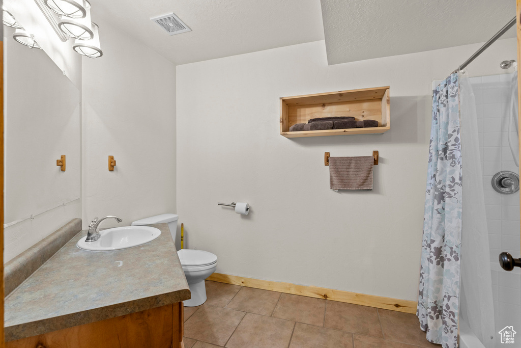 Full bath featuring vanity and tile patterned floors