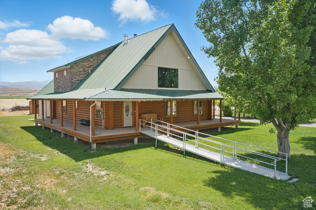 Back of house featuring a porch, a yard, and a metal roof