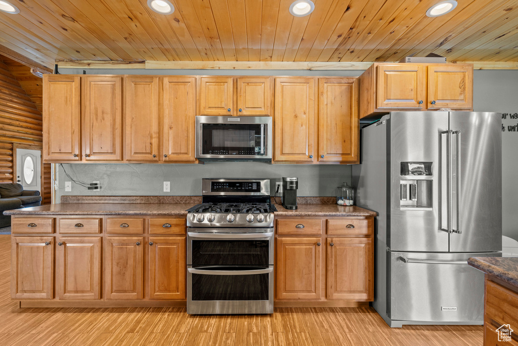 Kitchen with appliances with stainless steel finishes, recessed lighting, wood ceiling, dark countertops, and light wood-type flooring